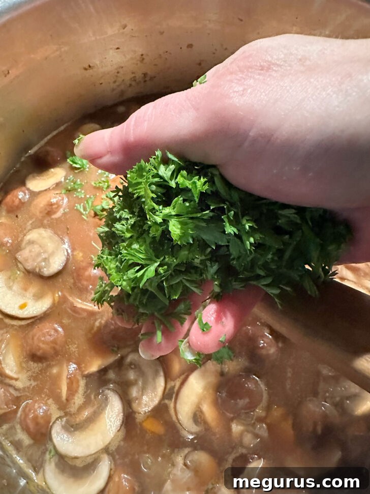 Finishing the mushroom barley soup with a sprinkle of fresh chopped parsley.