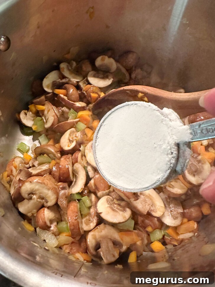 Sprinkling flour over the vegetables and mushrooms in the soup pot.
