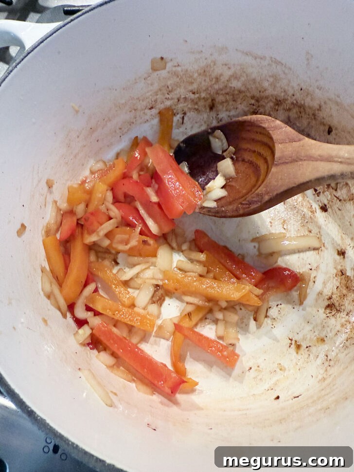 Diced onion and thinly sliced bell pepper cooking in the soup pot after mushrooms have been removed.