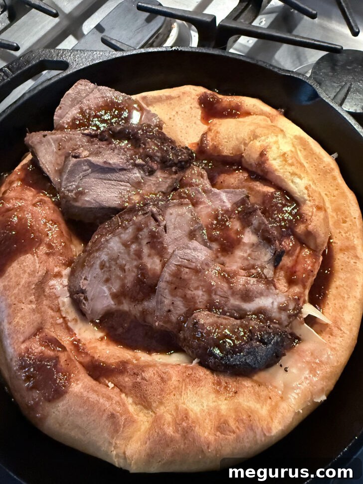 Topping the Yorkshire pudding with a generous amount of leftover roast beef and gravy.