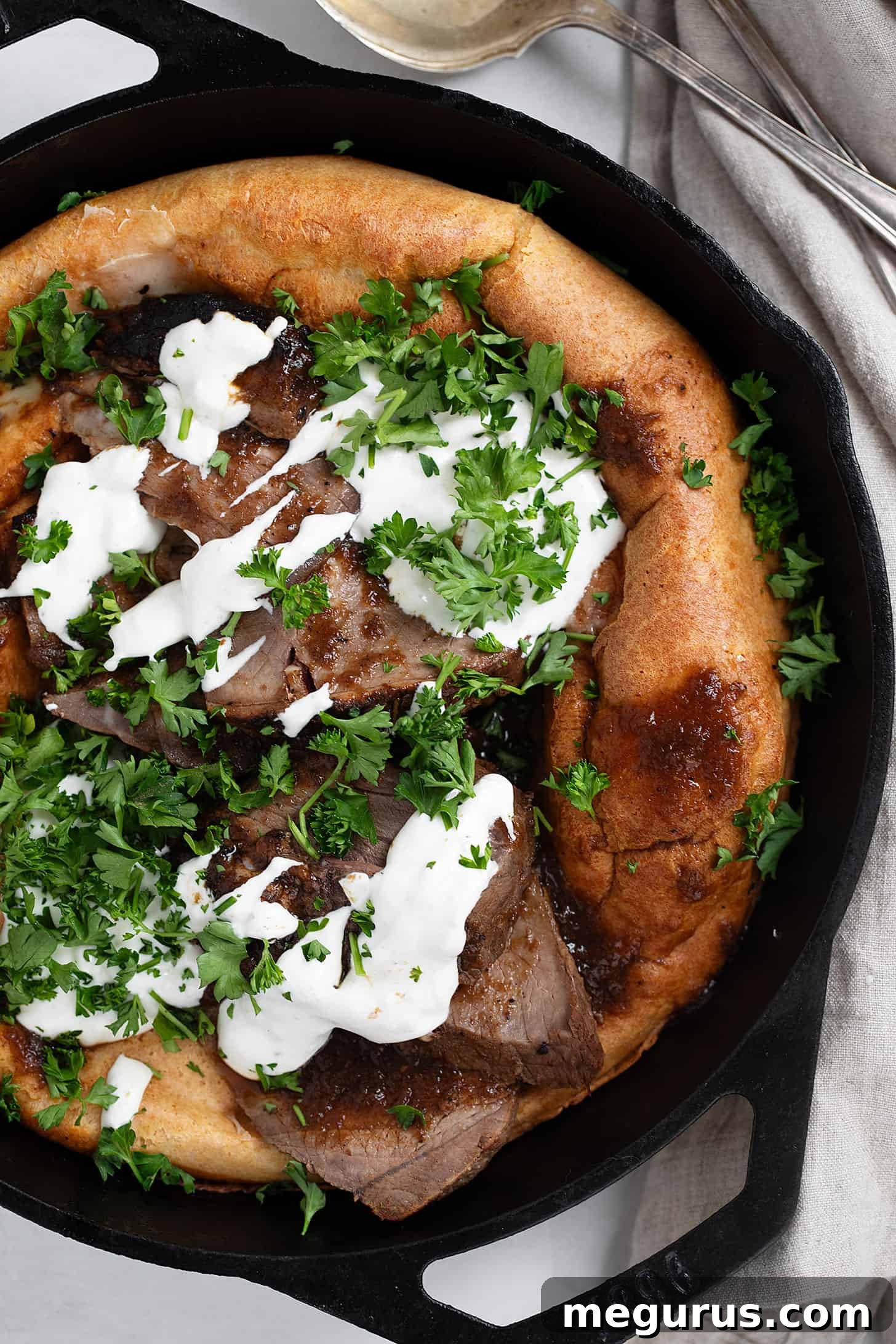 Close-up of Leftover roast beef and Yorkshire pudding in a cast iron skillet, ready to be served.
