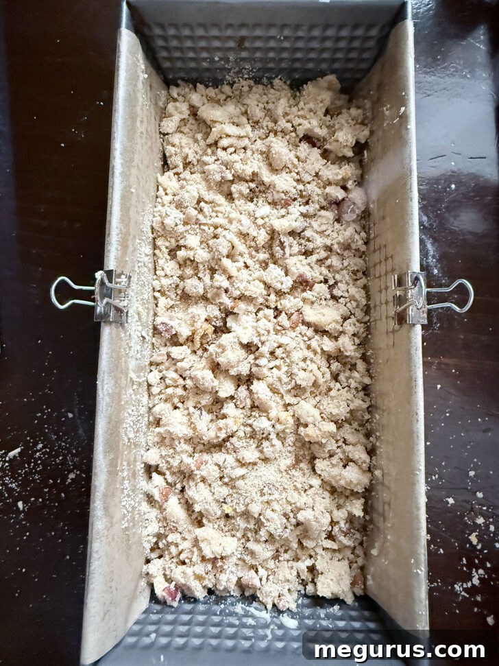 The chocolate chip coffee cake loaf in its pan, topped generously with the pecan crumb mixture, poised for baking.