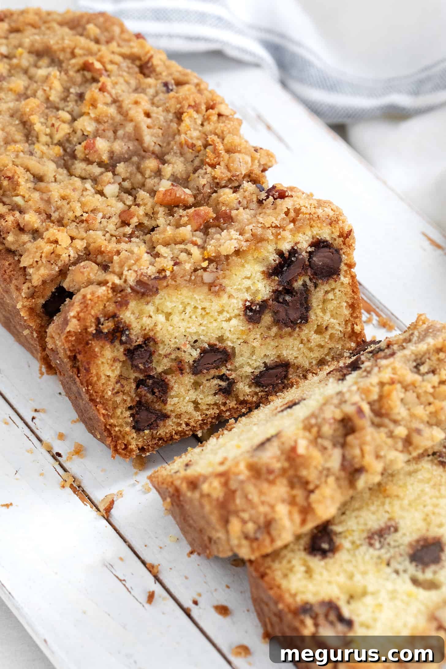 A warm, inviting chocolate chip coffee cake loaf, beautifully sliced and ready for serving on a cutting board, highlighting its rich textures.