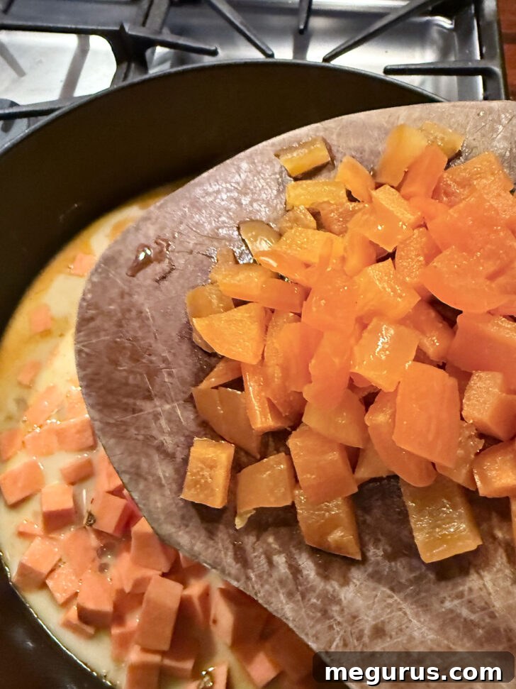 Adding diced bell pepper to the skillet for color and texture.