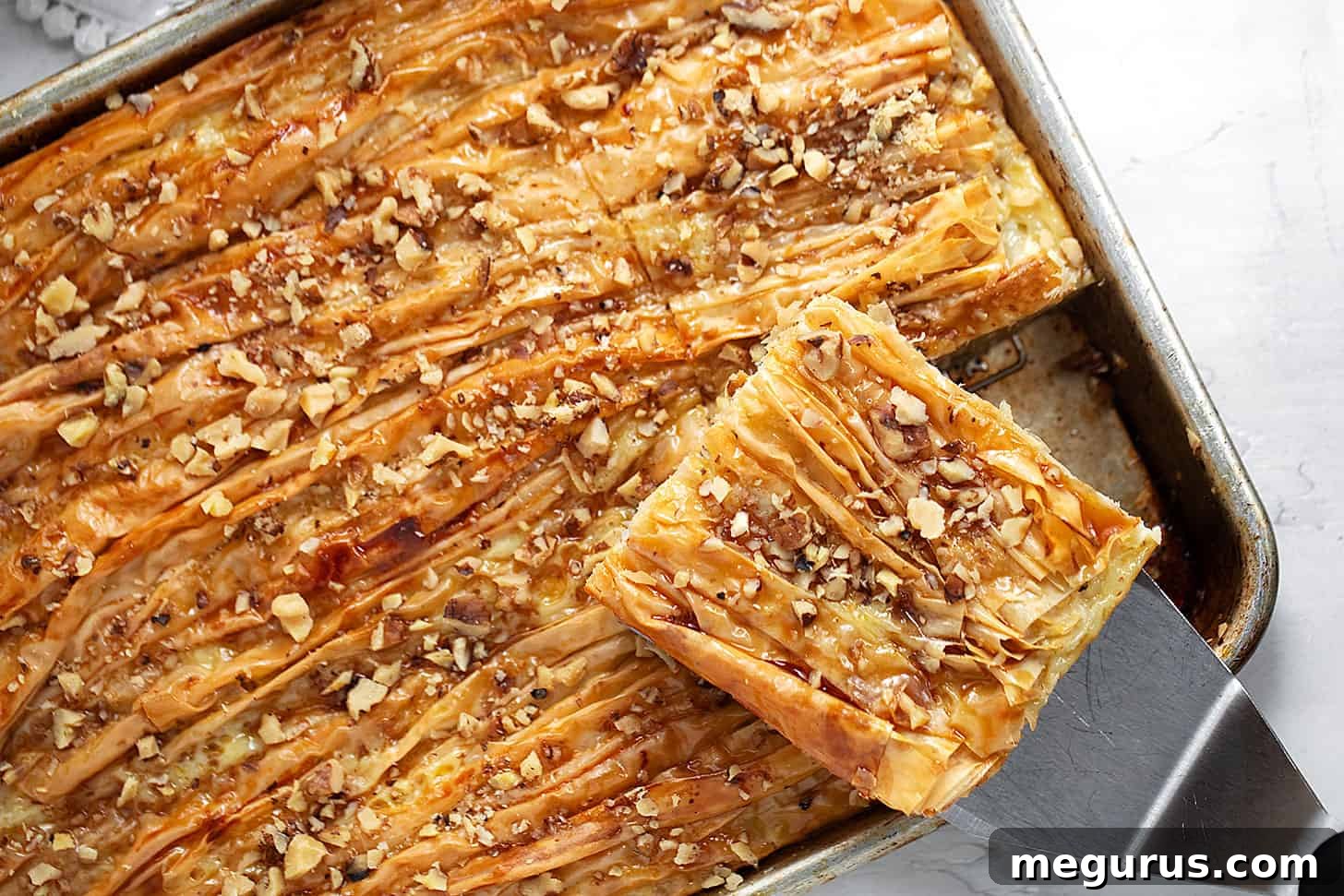Golden brown maple crinkle cake, freshly baked and sliced, resting on a baking sheet.
