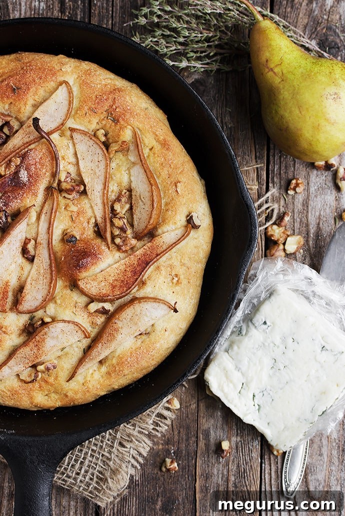 Close-up of freshly baked Pear and Walnut Focaccia with gorgonzola, honey, and a glass of white wine