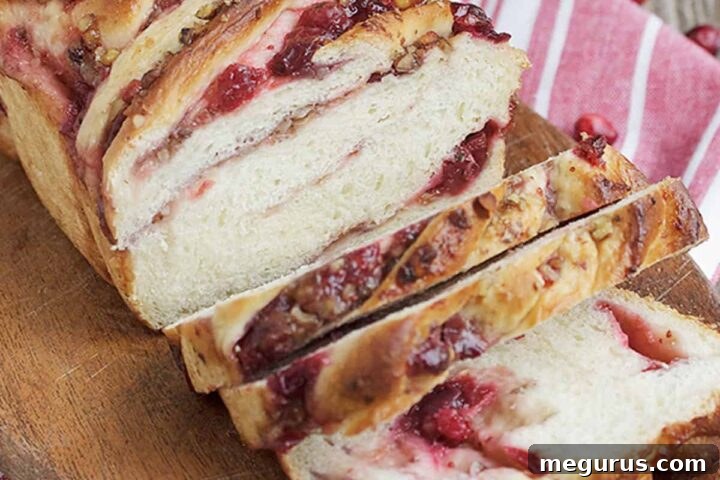 Cranberry walnut swirl bread sliced, showing the deep red swirl and golden crust