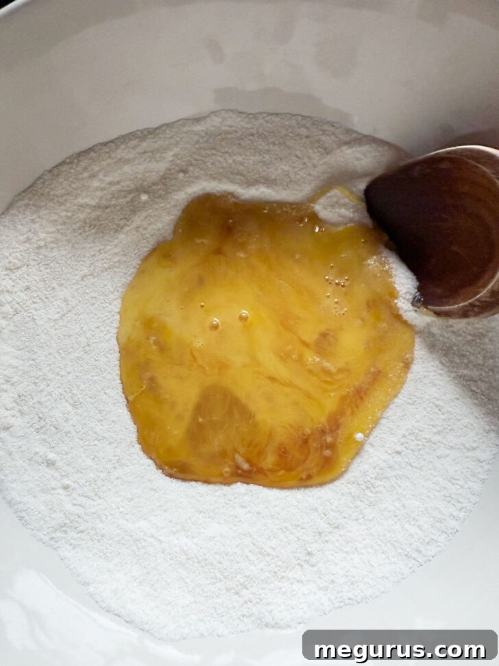Egg yolks being added to the dry ingredients (flour and sugar) in a mixing bowl for the pie filling.