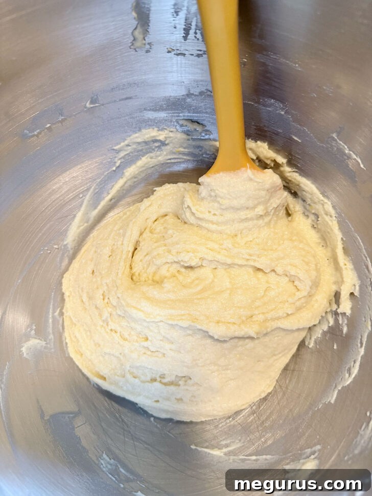 Muffin batter after mixing butter, eggs, and vanilla, showing a smooth consistency.