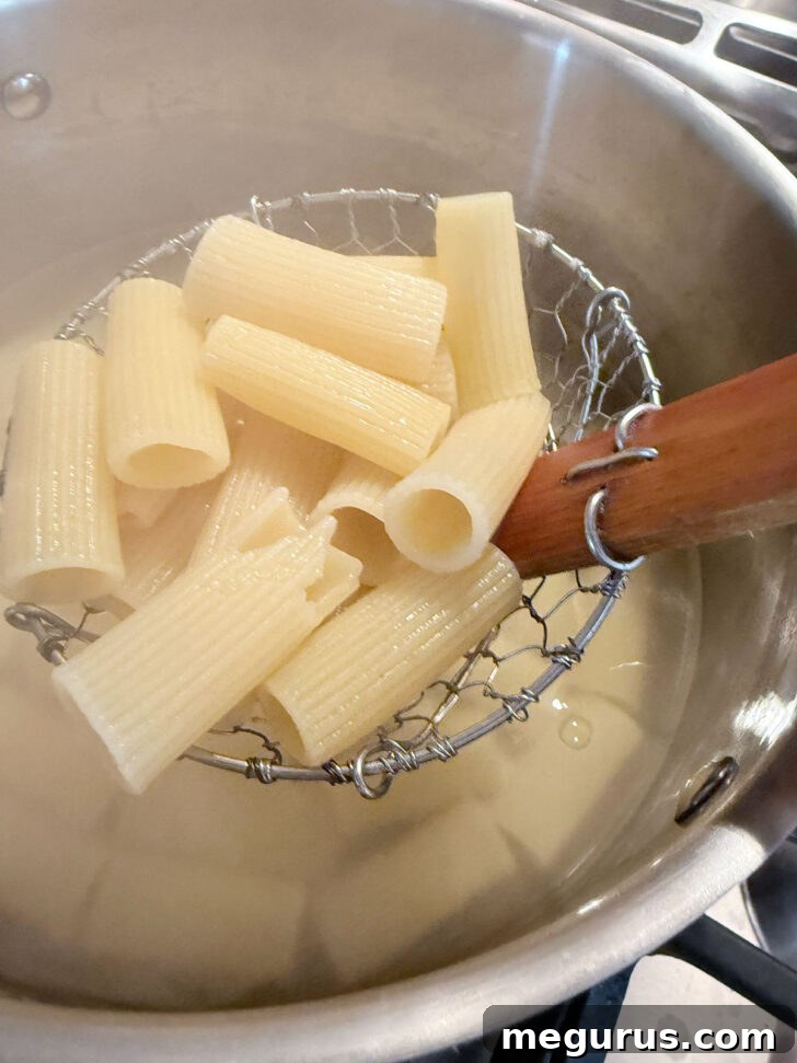 Spooning out cooked pasta from boiling water.