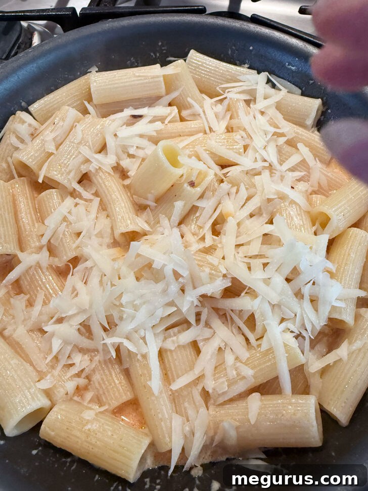 Adding Parmesan cheese to the skillet.