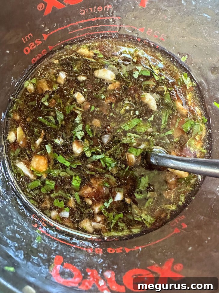 Marinade after stirring together, showing a rich, brown color and fragrant herbs.