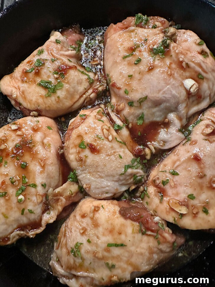 Marinated chicken thighs neatly arranged in a baking pan, skin-side up, before baking.