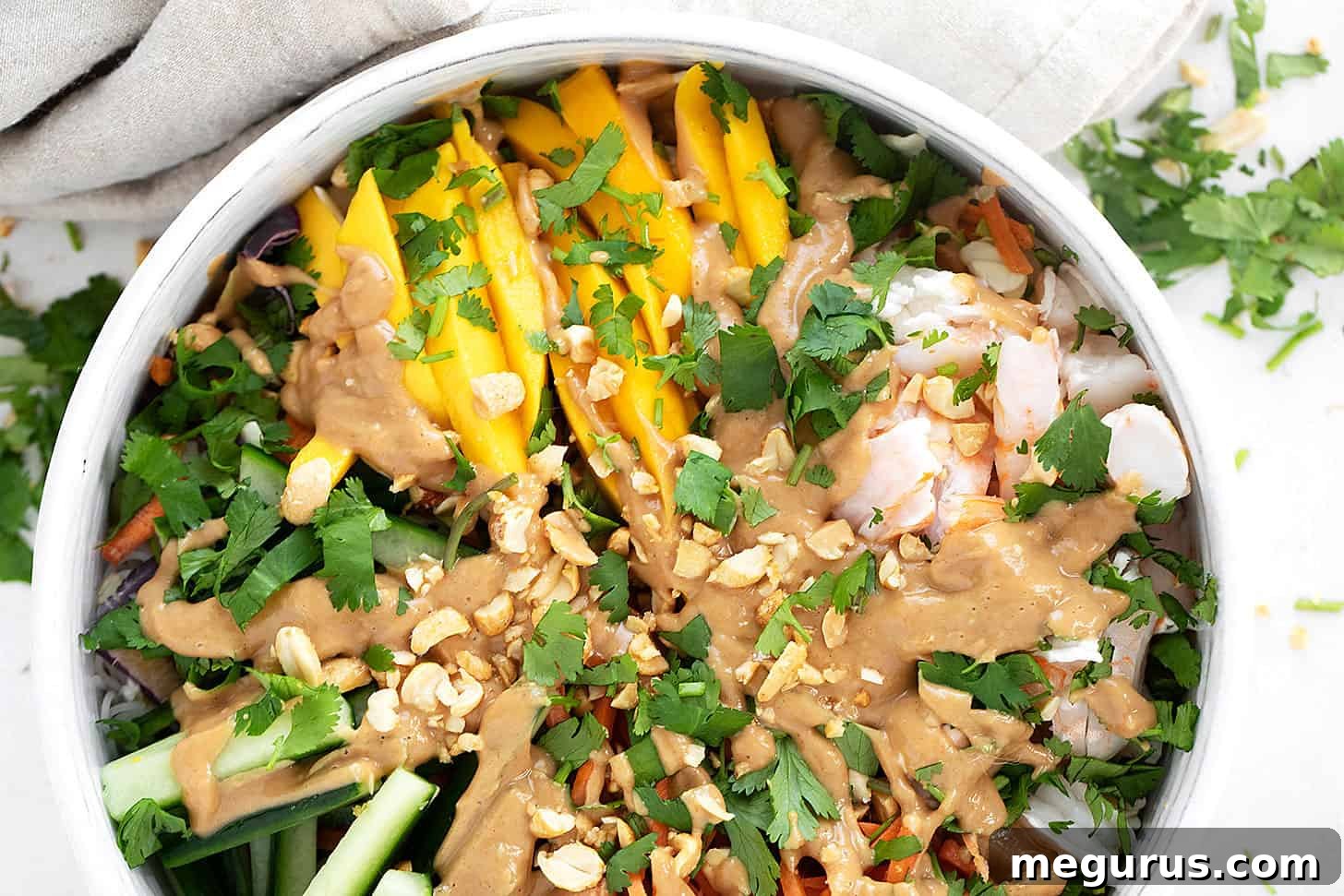 A beautifully presented Summer roll salad in a large serving bowl, showcasing layers of noodles, colorful vegetables, and shrimp.