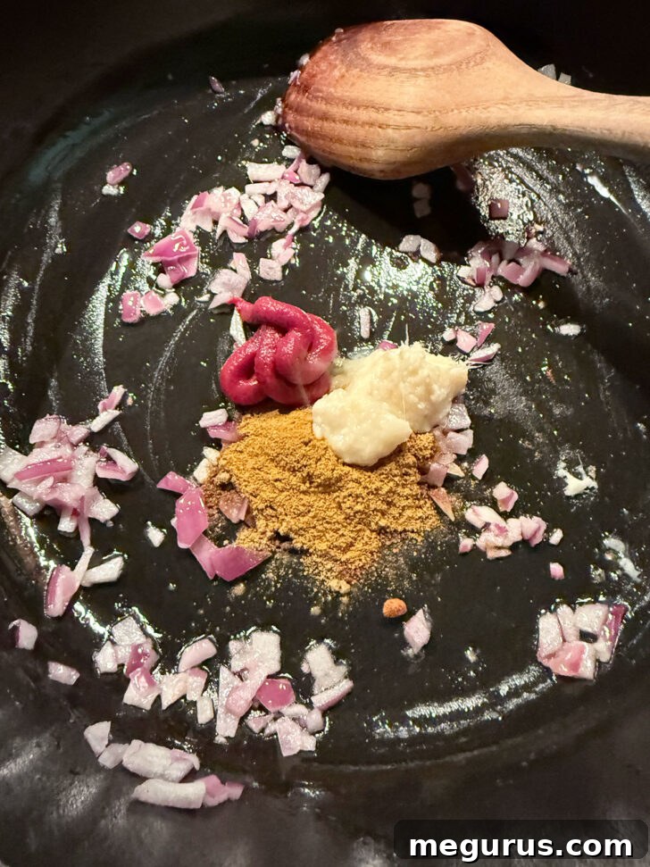 Cooking the spices in the skillet with the onion.