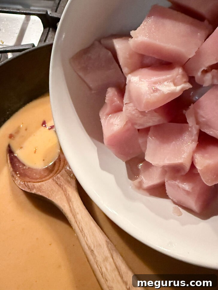 Chicken being added to the skillet.