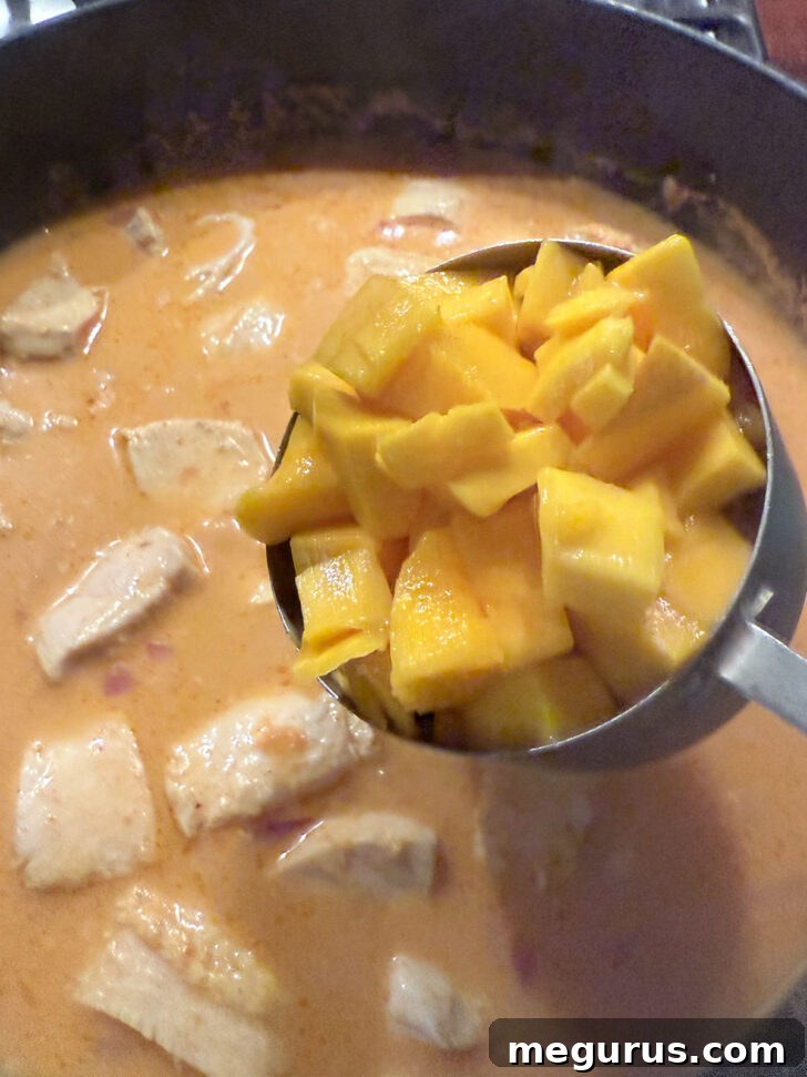 Adding diced mango to the skillet.