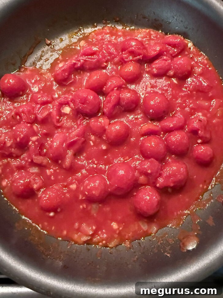 Canned cherry tomatoes added to the skillet.