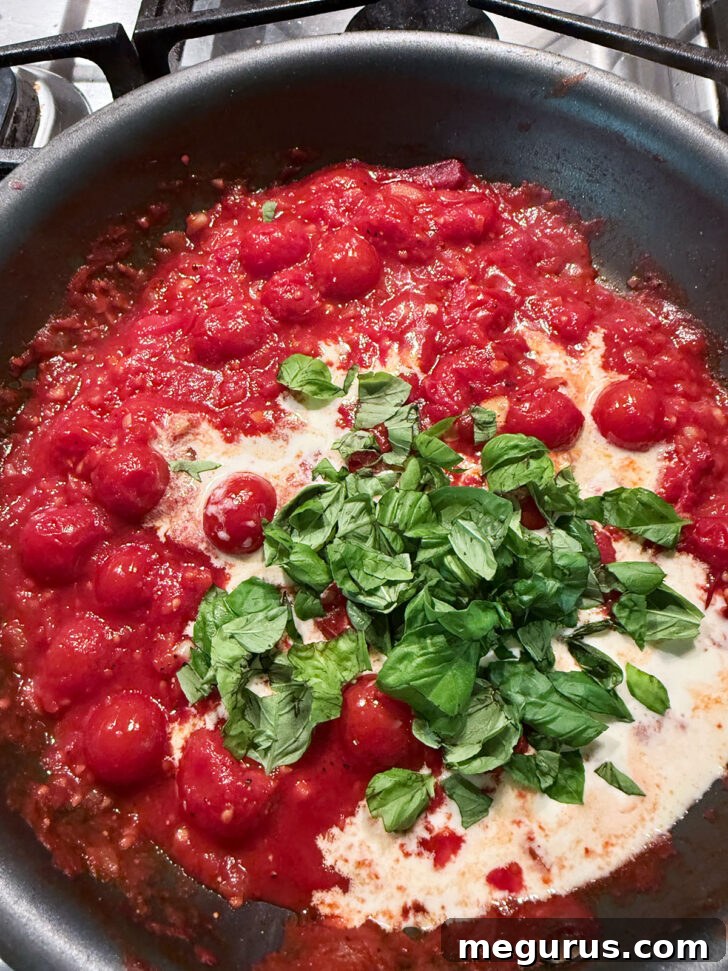 Adding fresh basil to the skillet.