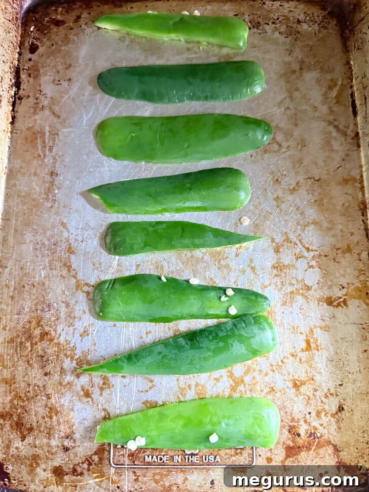 Fresh jalapeño slices arranged on a baking sheet, ready for roasting.