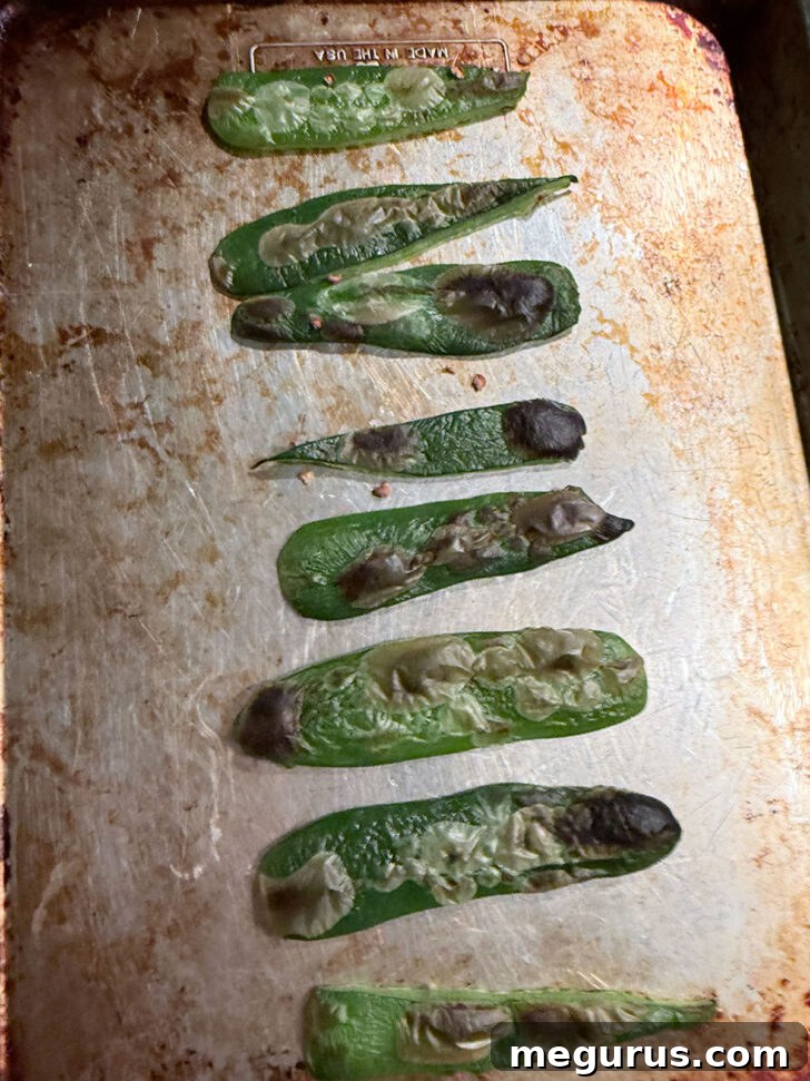 Roasted jalapeño slices, bubbly and slightly blackened after broiling.