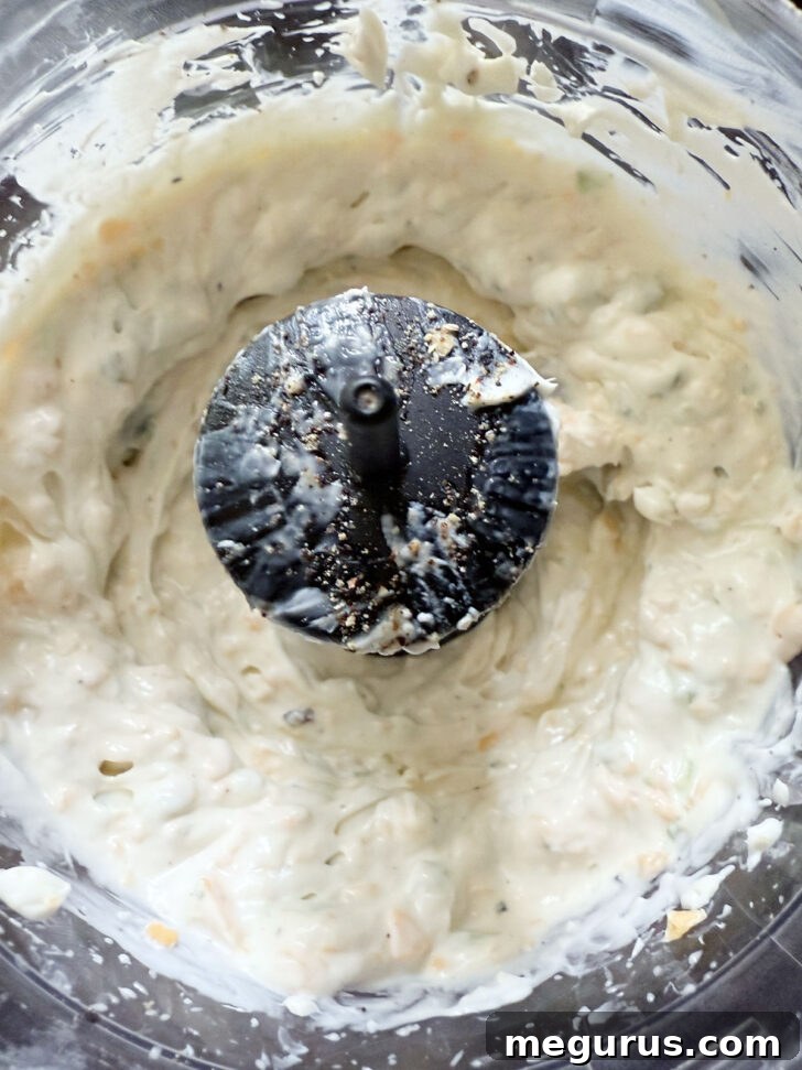 The creamy dressing after being processed, showing a smooth but not entirely uniform texture.