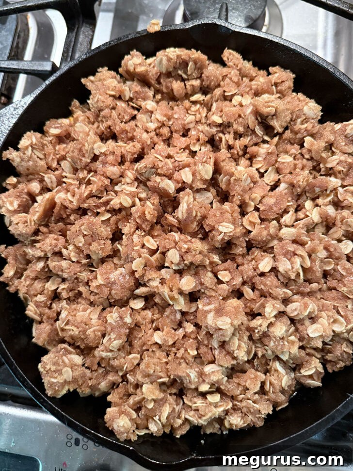 Crisp topping generously spread over the fruit filling in a baking dish, before the final bake.