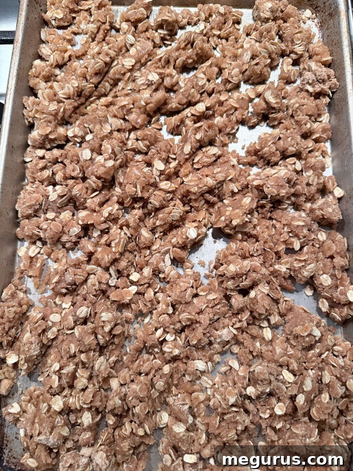 Crisp topping mixture spread evenly onto a parchment-lined baking sheet.