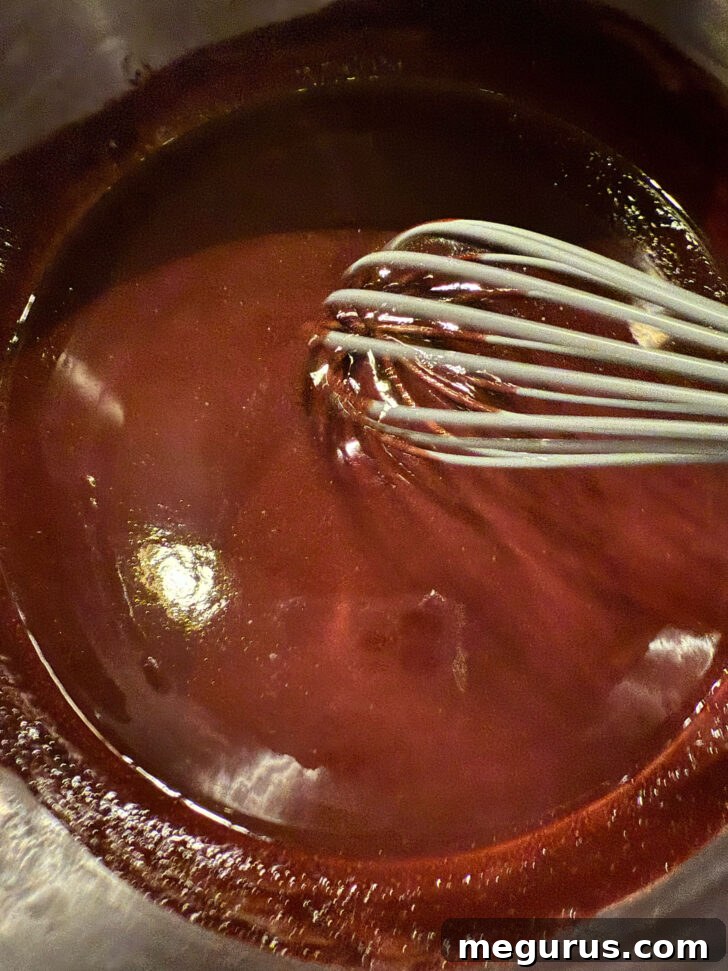 The butter and cocoa mixture in a saucepan, now smooth and slightly thickened after the egg has been whisked in, ready for dry ingredients.