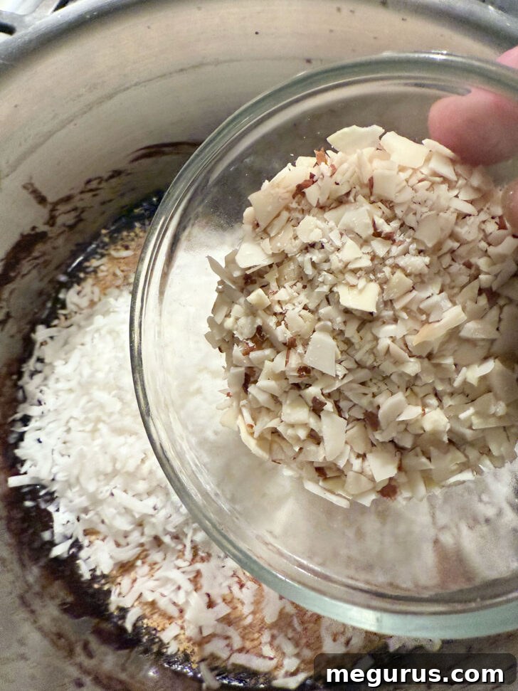 Graham cracker crumbs, shredded coconut, and chopped nuts being stirred into the melted chocolate mixture in a bowl, creating the crunchy base.