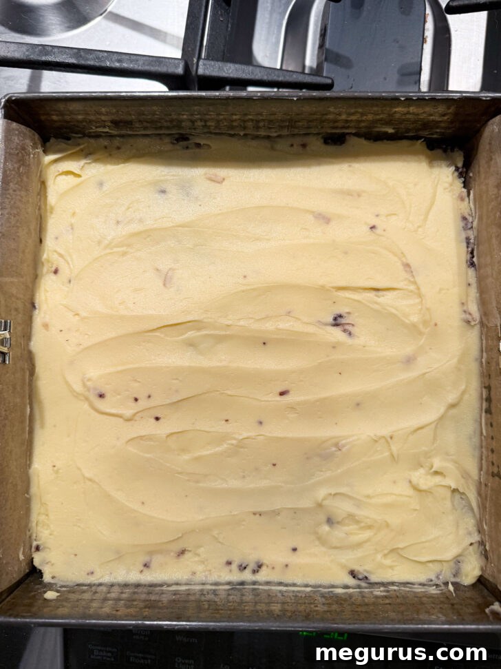 The creamy yellow custard filling spread smoothly and evenly over the dark chocolate base layer in the baking pan.