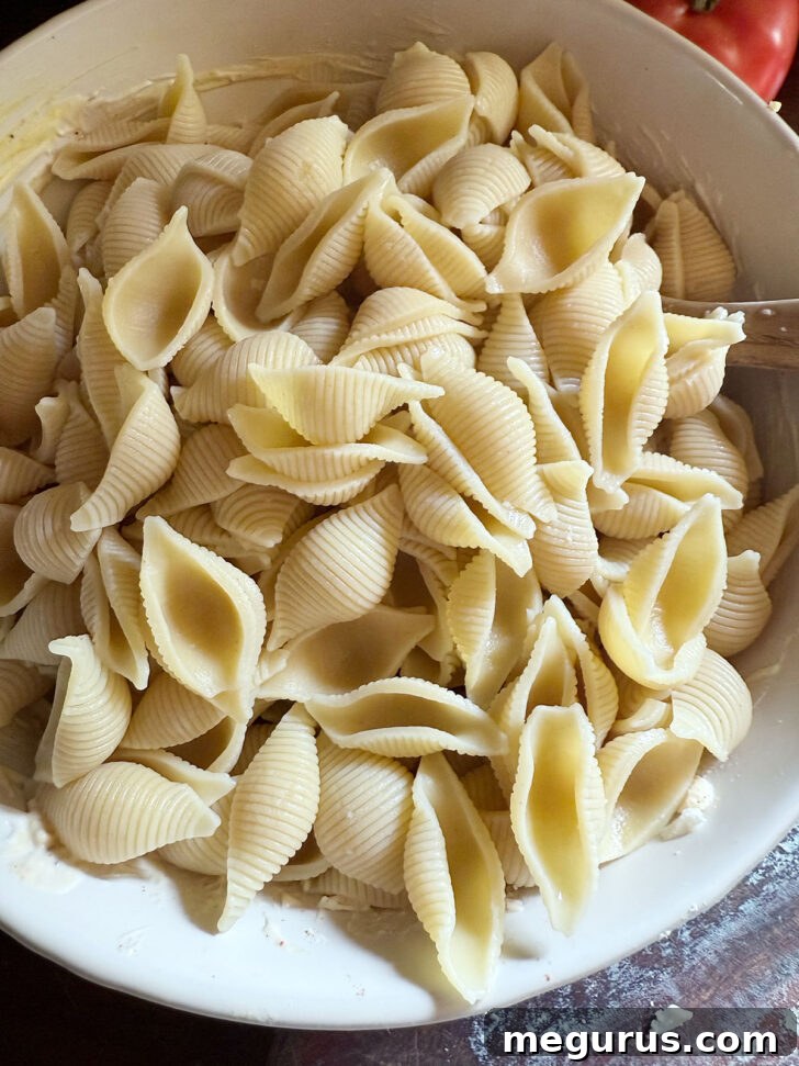Cooked, rinsed, and cooled shell pasta added to the mixed salad ingredients.
