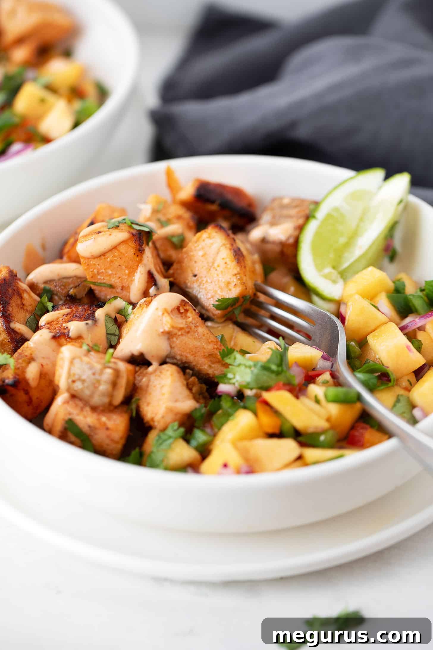 Chili lime salmon with peach salsa presented in a white serving bowl.