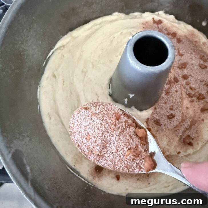 Sprinkling the cinnamon layer onto the batter in the tube pan.