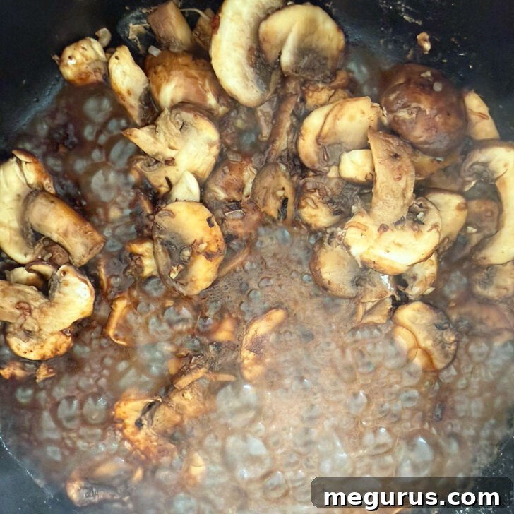Dry Marsala wine being poured into a skillet with sautéed mushrooms, creating a flavorful deglazing effect.