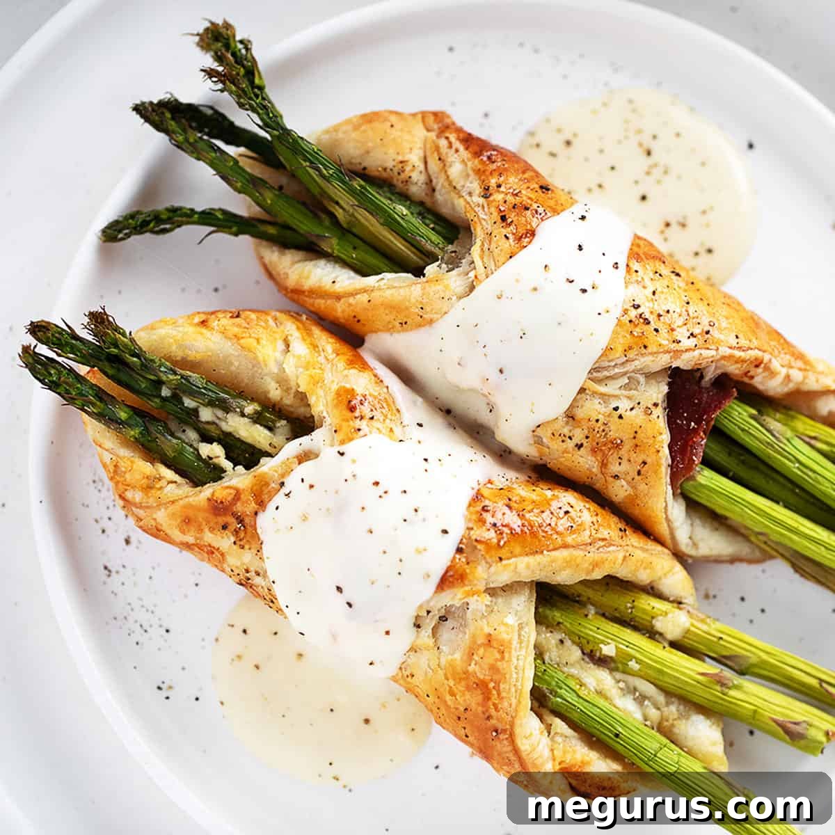 Asparagus filled puff pastry and prosciutto with cheese sauce.