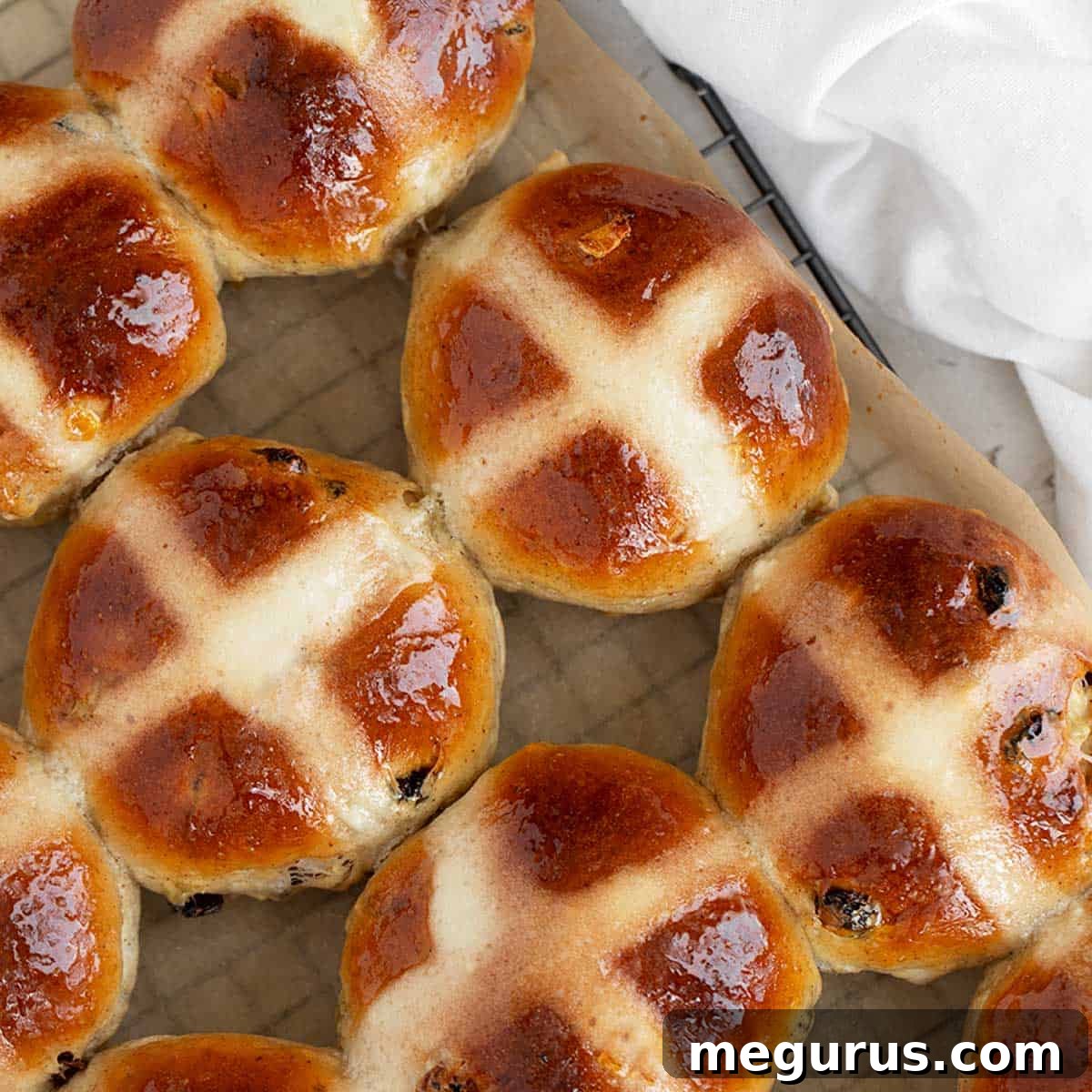 Traditional Hot Cross Buns cooling on a wire rack, with flour crosses.