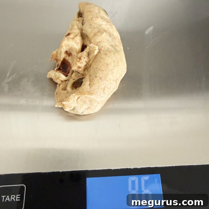 Dough balls are precisely weighed on a digital scale to ensure consistent bun sizes.