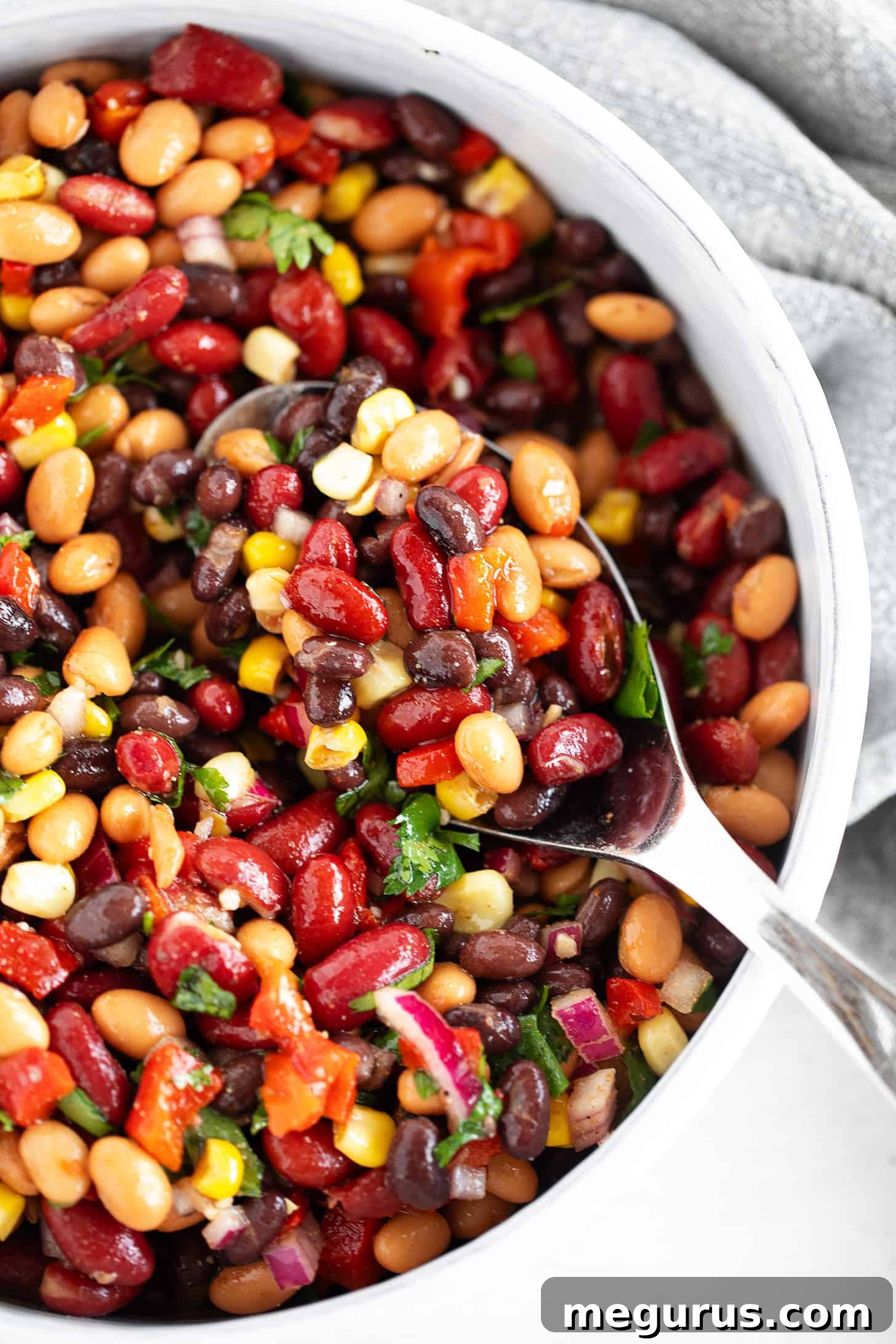 Mexican bean salad in a serving bowl with a spoon.