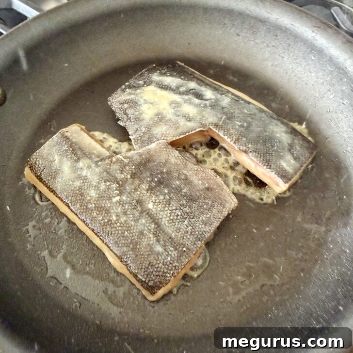 Cooking the black cod in a skillet.