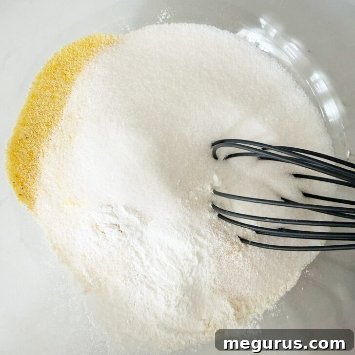 Dry ingredients in a bowl with a whisk.