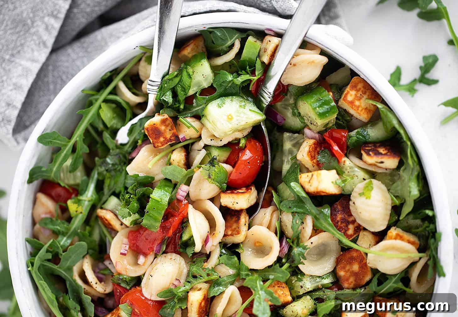 Orecchiette Pasta Salad with Crispy Halloumi and Lemon Dressing 2 Orecchiette and halloumi salad in a salad bowl with serving spoons.
