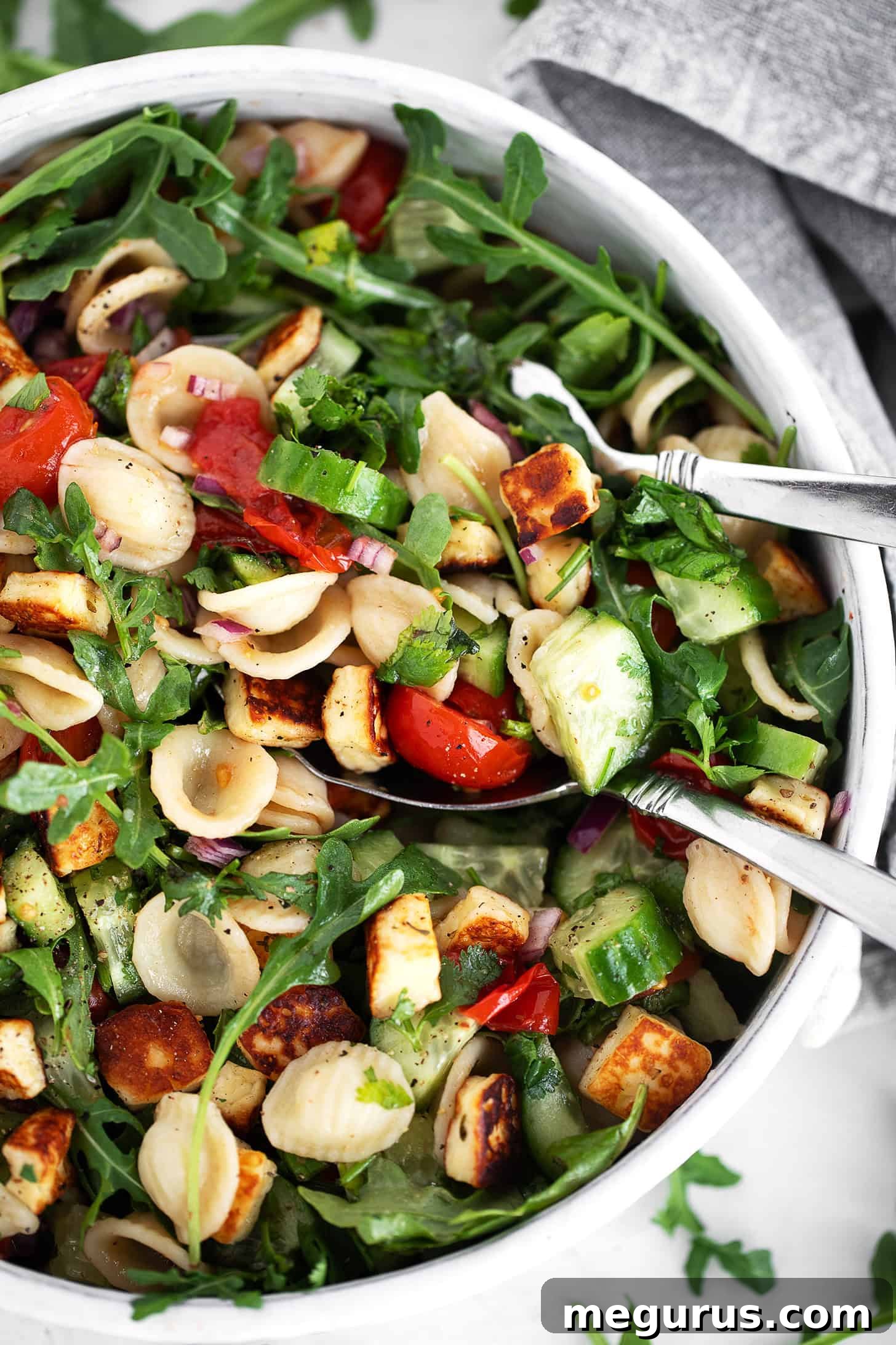 Orecchiette Pasta Salad with Crispy Halloumi and Lemon Dressing 11 Orecchiette and halloumi salad in a salad bowl with serving spoons.