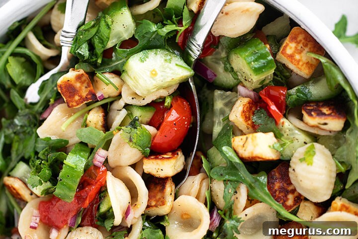 Orecchiette Pasta Salad with Crispy Halloumi and Lemon Dressing 12 Orecchiette and halloumi salad in a salad bowl with serving spoons.