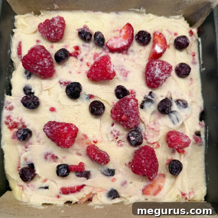 A bit more fruit scattered on top of the cake before baking.