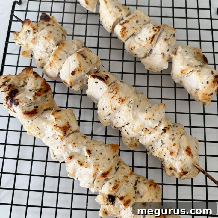 Grilled Chicken Souvlaki Salad with Tzatziki and Lemon Dressing 6 Chicken souvlaki skewers on a cooling rack after cooking.